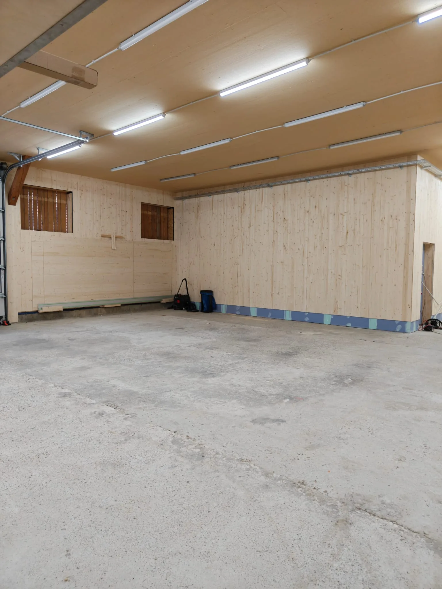 Neue Werkstatt der Schreinerei Gleinig am Dietrichhof mit hellen Holzverkleidungen, Betonboden und LED-Beleuchtung
